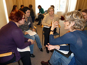 Eine Gruppe von Frauen diskutiert im Kreis sitzend